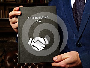 ANTI-BULLYING LAW book in the hands of a jurist. Anti-bullying lawsÂ are one prevention strategy that can change social norms